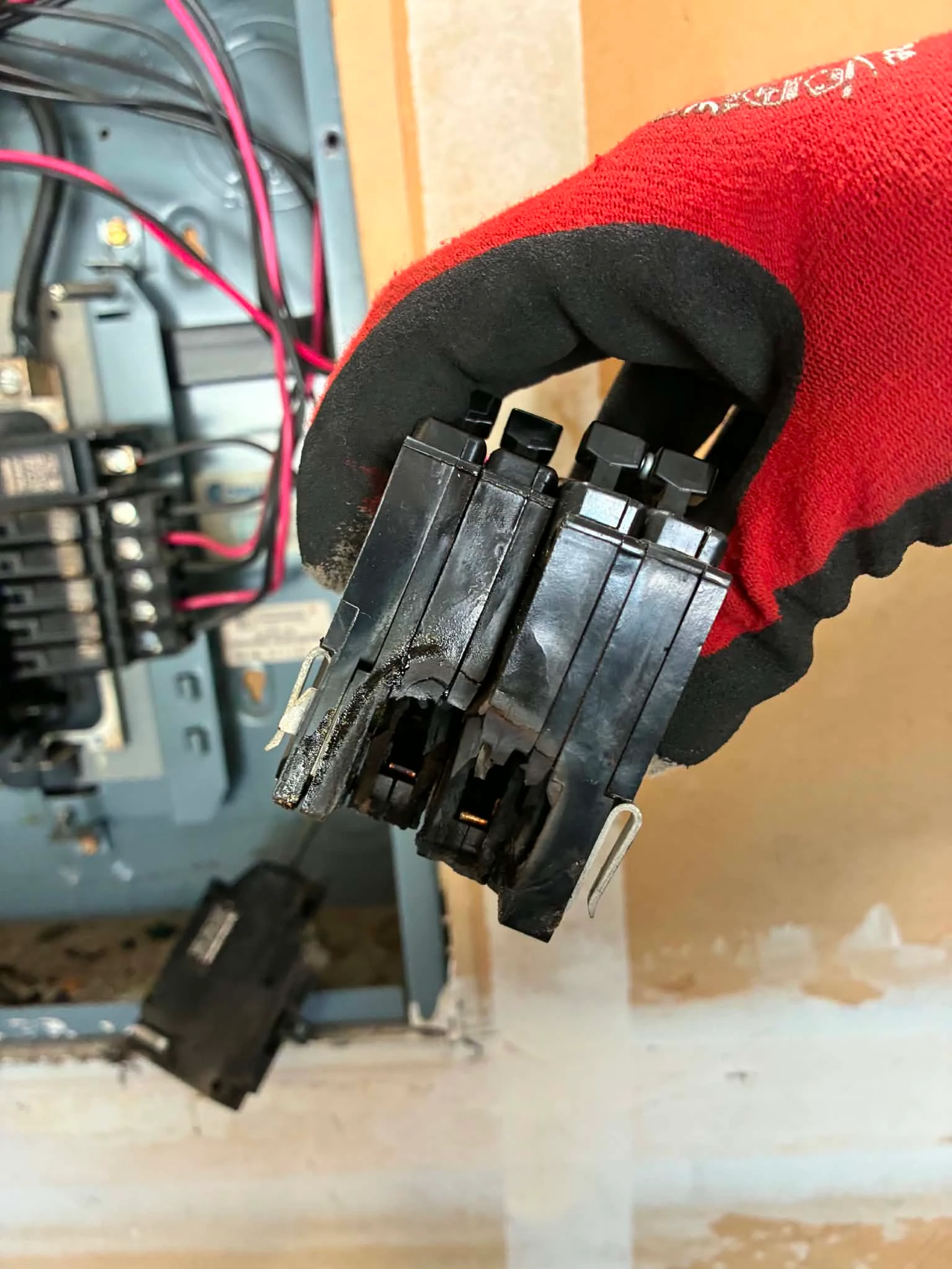 Heat-damaged circuit breakers removed during a residential electrical panel inspection