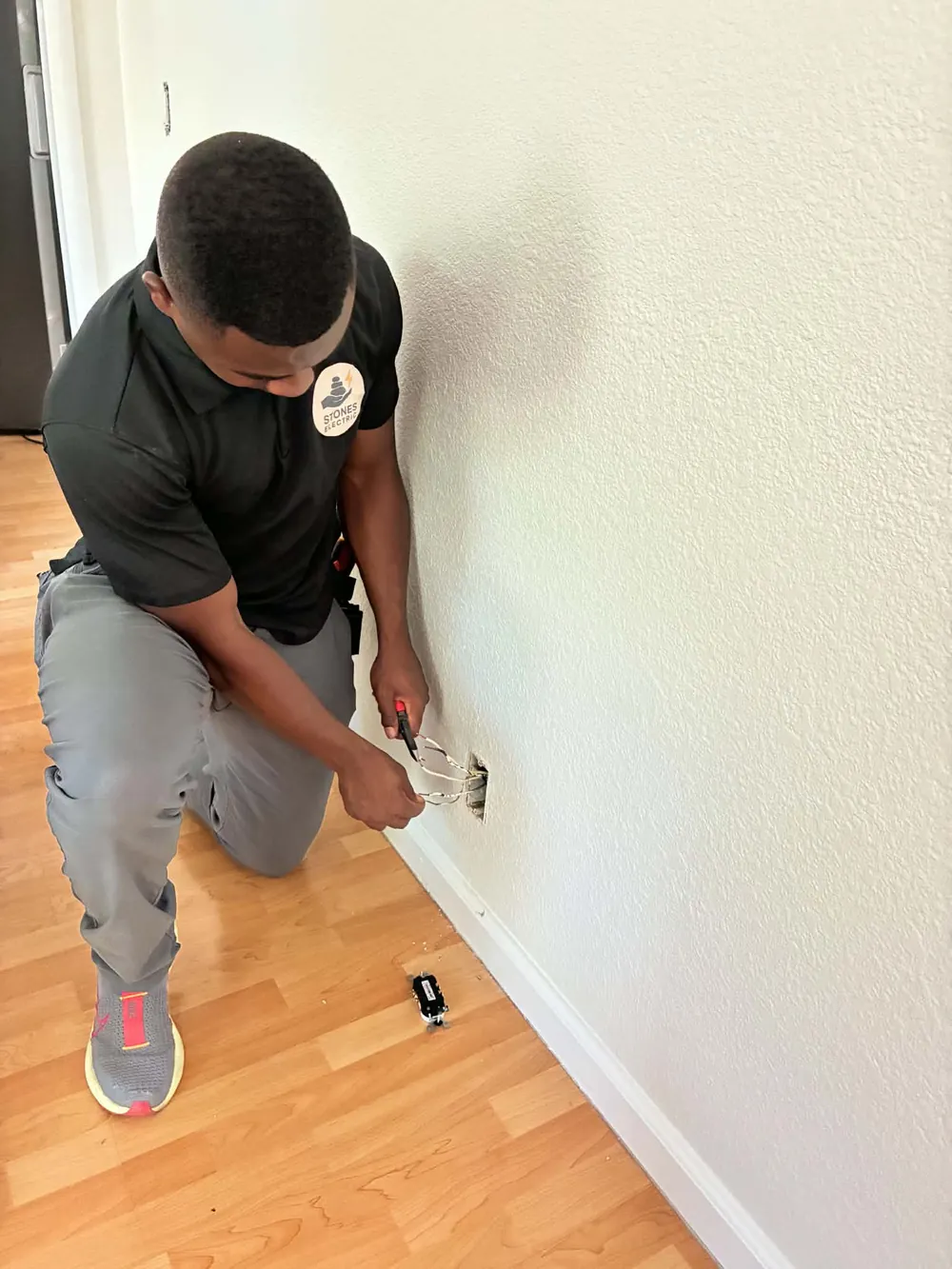 Adrian James-Irby of Stones Electric working on a residential electrical outlet